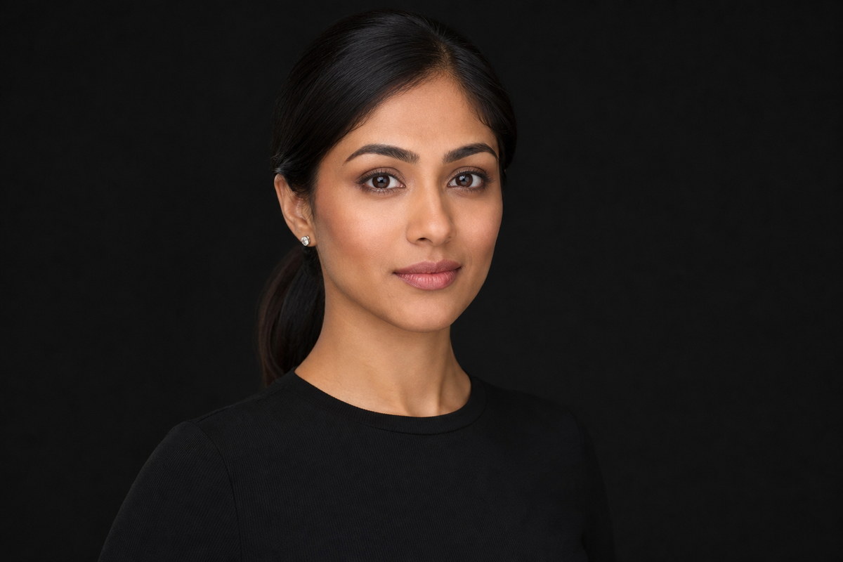 Professional studio headshot in black against a dark background.
